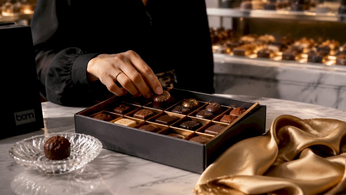 Pralinensortiment in einer offenen Geschenkbox mit Geschmacksübersicht